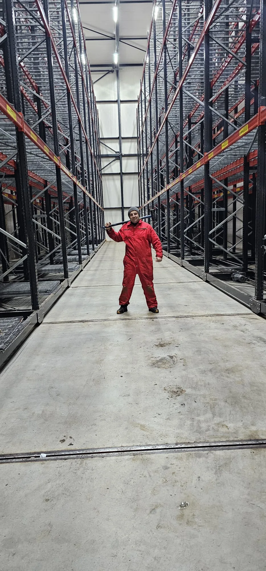 Werker in rode overall in industrieel magazijn