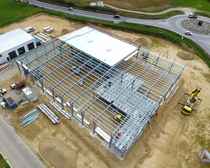 Bouw van een staalconstructie met een open structuur en een terrein vol materialen